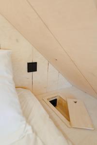 a room with a bed and a small opening in the ceiling at Unique Tiny House at Saaremaa Golf & Country Club in Kuressaare