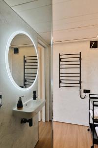 La salle de bains est pourvue d'un lavabo et d'un miroir. dans l'établissement Unique Tiny House at Saaremaa Golf & Country Club, à Kuressaare