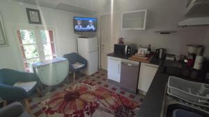 a kitchen with a refrigerator and a tv on the wall at Vernet Jardin in Vernet-les-Bains