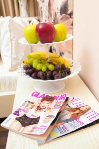 une exposition de fruits sur une table à côté de magazines dans l'établissement Vivar Hotel, à Tirana