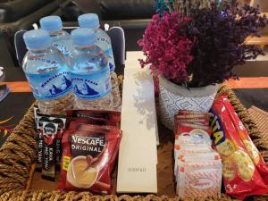 a table with bottles of water and a vase with flowers at Resort-type, spacious 1 bedroom condo in Kandi. in Angeles