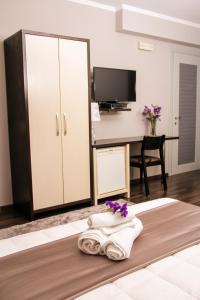 Habitación con 1 cama con toallas y escritorio. en Vivar Hotel, en Tirana