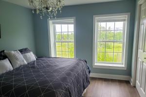 ein Schlafzimmer mit einem Bett und zwei Fenstern in der Unterkunft Vibrant Views in Ludlow