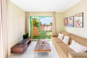 a living room with a couch and a tv at Holiday World RIWO Hotel. in Benalmádena