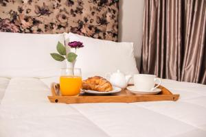 - un plateau avec un petit-déjeuner composé de jus d'orange et de croissants dans l'établissement Vivar Hotel, à Tirana