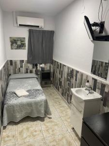 a small room with a bed and a sink at Hostal Restaurante Avenida de Madrid in Terrassa