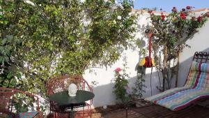eine Terrasse mit einem Tisch und Stühlen im Garten in der Unterkunft Le Mas Romantique avec Jacuzzi et Sauna privé in Sénas