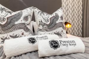 een stapel handdoeken en kussens op een bed bij 5th On Preston Guest House in East London
