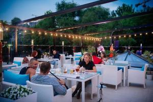 a group of people sitting at a table on a patio at Apartments & Villa Georg in Odesa +109 photos