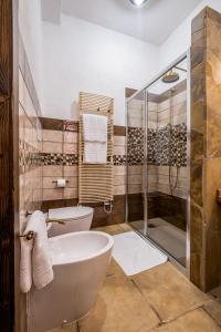 a bathroom with a tub and a toilet and a shower at Il Rifugio dei Minatori in Iglesias