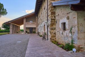 a large stone building with a pathway in front of it at Casale San Pietro in Palmanova