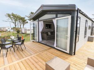 an open deck with a table and chairs on a house at Puffin Lodge in Haverfordwest