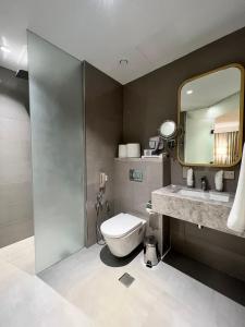 a bathroom with a toilet and a sink and a mirror at City Seasons Suites in Dubai