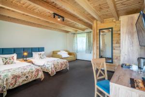 a hotel room with two beds and a couch at Łabędź Hotel Karczma in Iława