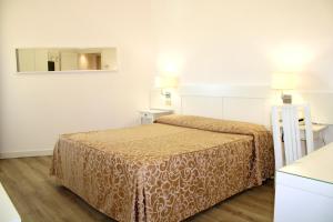 una camera d'albergo con letto e specchio di Hotel Esplanade a Marina di Pietrasanta