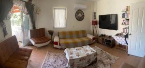 a living room with a couch and a tv at Triplex house, near center and sea in Datca