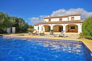 une villa avec une piscine en face d'une maison dans l'établissement Villa Tranquila - PlusHolidays, à Benissa