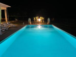 a large blue swimming pool at night at Quinta da Menina Guest House in Vila Real