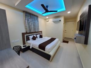 a bedroom with a bed with a ceiling fan at Kings Palace in Chennai