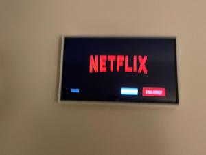 een televisie met de woorden Netflix op een muur bij Quinta da Menina Guest House in Vila Real