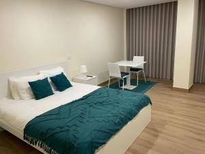 a bedroom with a bed and a table with chairs at Quinta da Menina Guest House in Vila Real