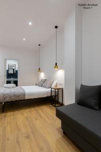 1 dormitorio con 2 camas, mesa y sofá en Hotelito Boutique Valencia Estación, en Valencia