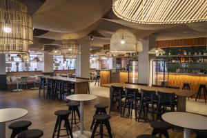 un bar con mesas y taburetes en un restaurante en Belambra Clubs La Grande Motte - Petite Camargue Presqu'île Du Ponant, en La Grande-Motte