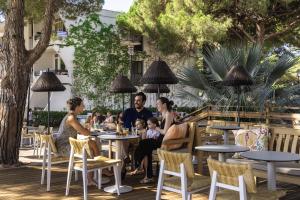 un groupe de personnes assises à table dans un restaurant dans l'établissement Belambra Clubs La Grande Motte - Petite Camargue Presqu'île Du Ponant, à La Grande Motte