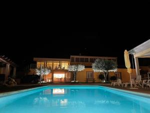 a swimming pool in front of a house at night at Quinta da Menina Guest House in Vila Real