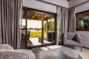 uma sala de estar com vista para um pátio em Simbavati Waterside em Reserva Natural Privada de Klaserie