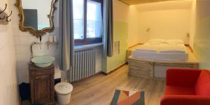 a bedroom with a bed and a chair and a window at Ostello Antagonisti in Melle