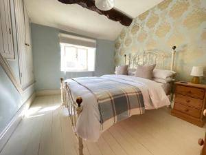 1 dormitorio con cama y ventana en Bobbin Cottage, en Bakewell