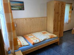 ein kleines Bett in einem Zimmer mit Fenster in der Unterkunft Apartmán u Marušky in Chřibská