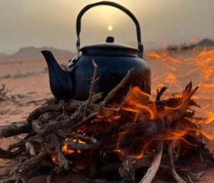 a tea kettle sitting on top of a campfire at Wadi Rum nature in Wadi Rum