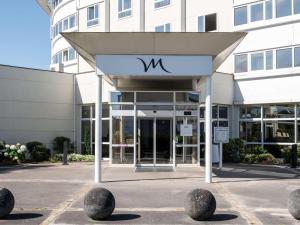 a building with a sign on the front of it at Mercure Compiègne Sud in Compiègne