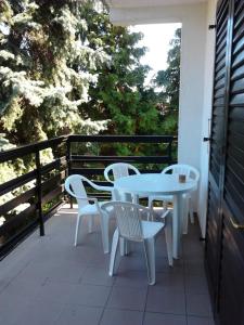 - Balcón con mesa blanca y sillas en Balatonberényi Vendégház, en Balatonberény