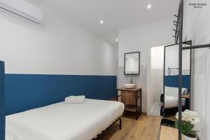 1 dormitorio con cama blanca y pared azul en Hotelito Boutique Valencia Estación, en Valencia