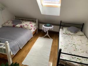 a bedroom with two beds and a table and a window at APARTMENT DOR-Ali u Ali in Żubracze