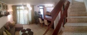 a room with a staircase and a living room with a table at Duplex Apartment in Edificio Altemar in Playa de las Americas