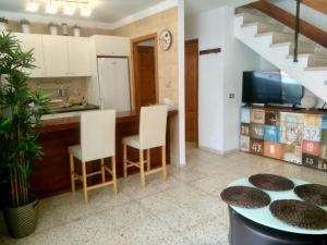 a kitchen with a table and chairs and a sink at Duplex Apartment in Edificio Altemar in Playa de las Americas