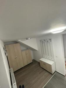 una stanza vuota con armadi in legno e soffitto bianco di Apartament STEFI a Sighişoara