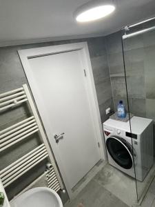 un piccolo bagno con lavatrice e porta di Apartament STEFI a Sighişoara