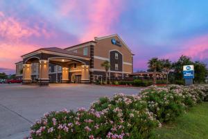 un hotel con flores frente a un edificio en Best Western Texas City, en Texas City