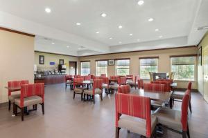 a dining room with tables and red chairs at Best Western Texas City in Texas City