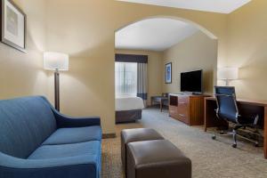 a hotel room with a bed and a couch and a desk at Best Western Texas City in Texas City