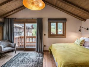 a bedroom with a bed and a chair and a window at Chalet moderne avec jacuzzi et 5 chambres, proche télécabine et ski-bus, Méribel Le Raffort - FR-1-566-14 in Les Allues