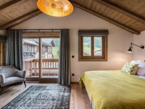 a bedroom with a bed and a chair and a window at Chalet Méribel, 6 pièces, 10 personnes - FR-1-566-14 in Les Allues