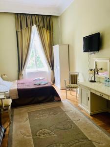 a bedroom with a bed and a window and a desk at Pałac Biedrusko in Poznań