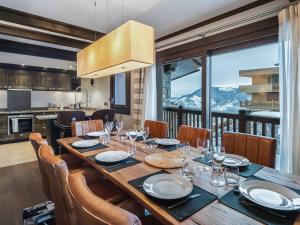 a dining room with a table and a kitchen at Splendide appartement centre Courchevel, 4 chambres, parking inclus - FR-1-563-64 in Courchevel