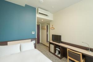 a bedroom with a bed and a desk with a tv at Rose Stay Tokyo Shiba Park in Tokyo